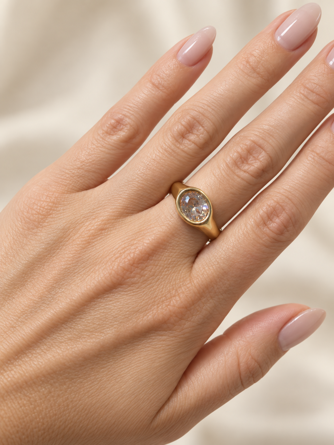 CORA Statement-Ring mit champagnerfarbenem Zirkonia am Finger getragen, vergoldeter Edelstahl