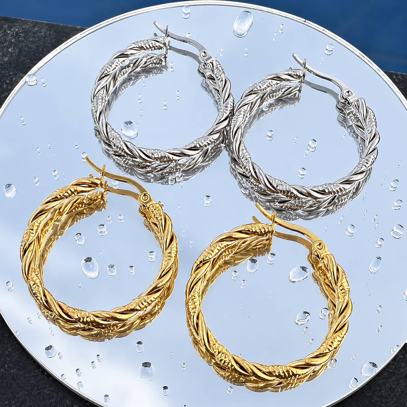 Creolen mit gedrehter Kordel-Optik in Gold- und Silberton, mehrere Paare auf Platte.