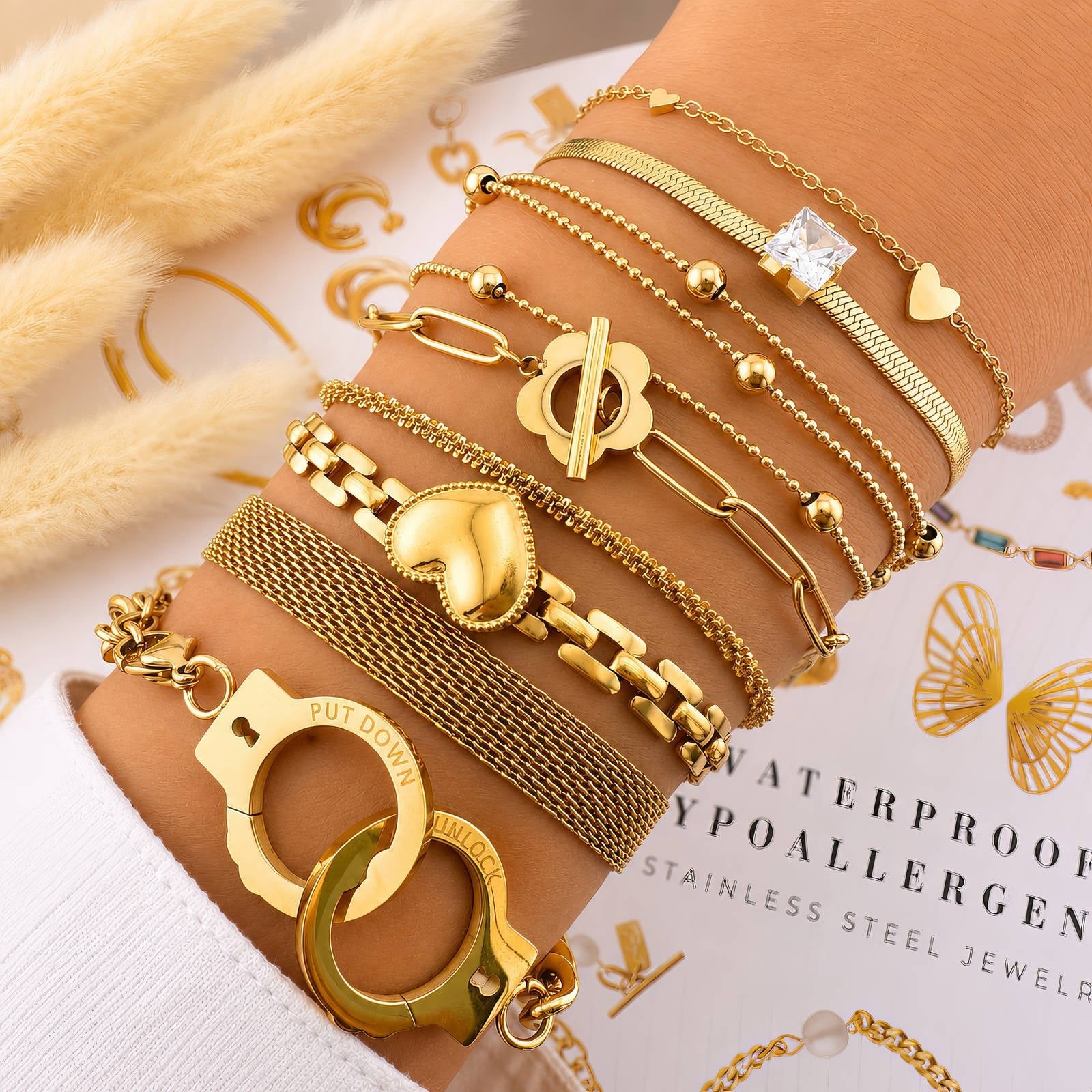 Mehrere goldfarbene Armbänder mit Mesh und Anhängern, detailreiche Kettenglieder