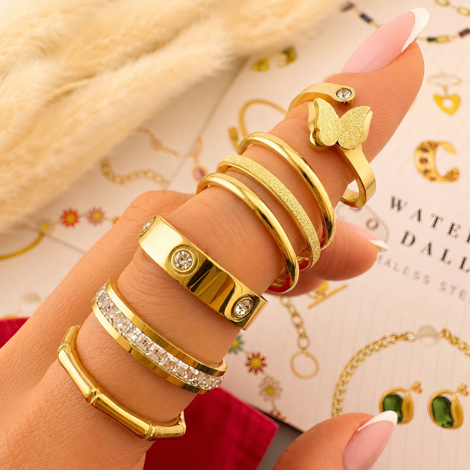 Mehrere goldfarbene Fingerringe mit Zirkonia und breiten, funkelnden Bändern