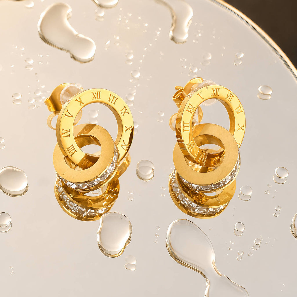 Goldfarbene Ohrstecker mit römischen Ziffern und Steinkranz im Ringdesign