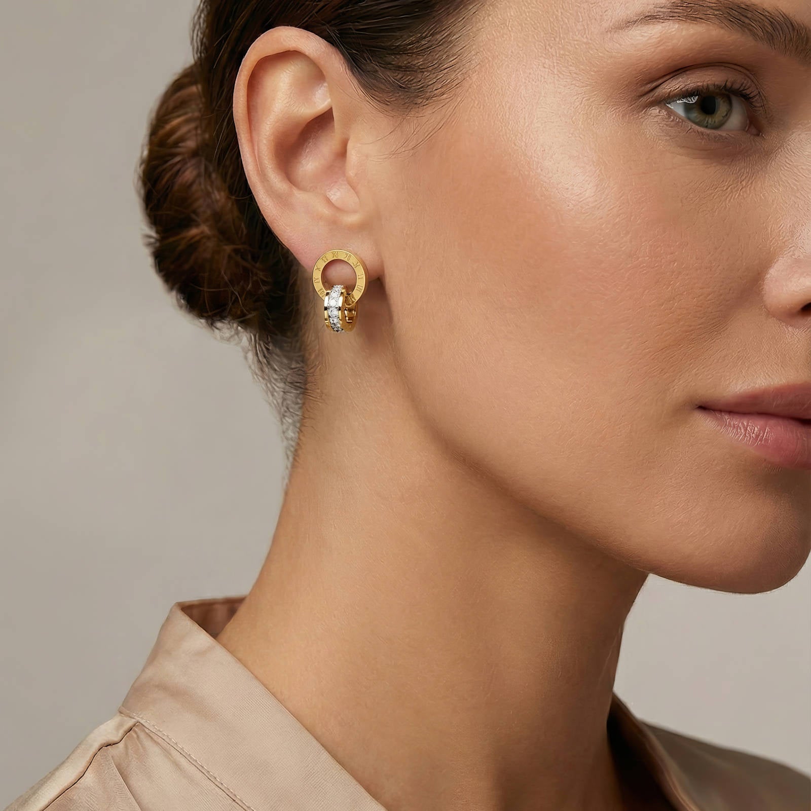 Ohrstecker am Ohr: goldfarbenes Ringdesign mit römischen Ziffern und klaren Steinen