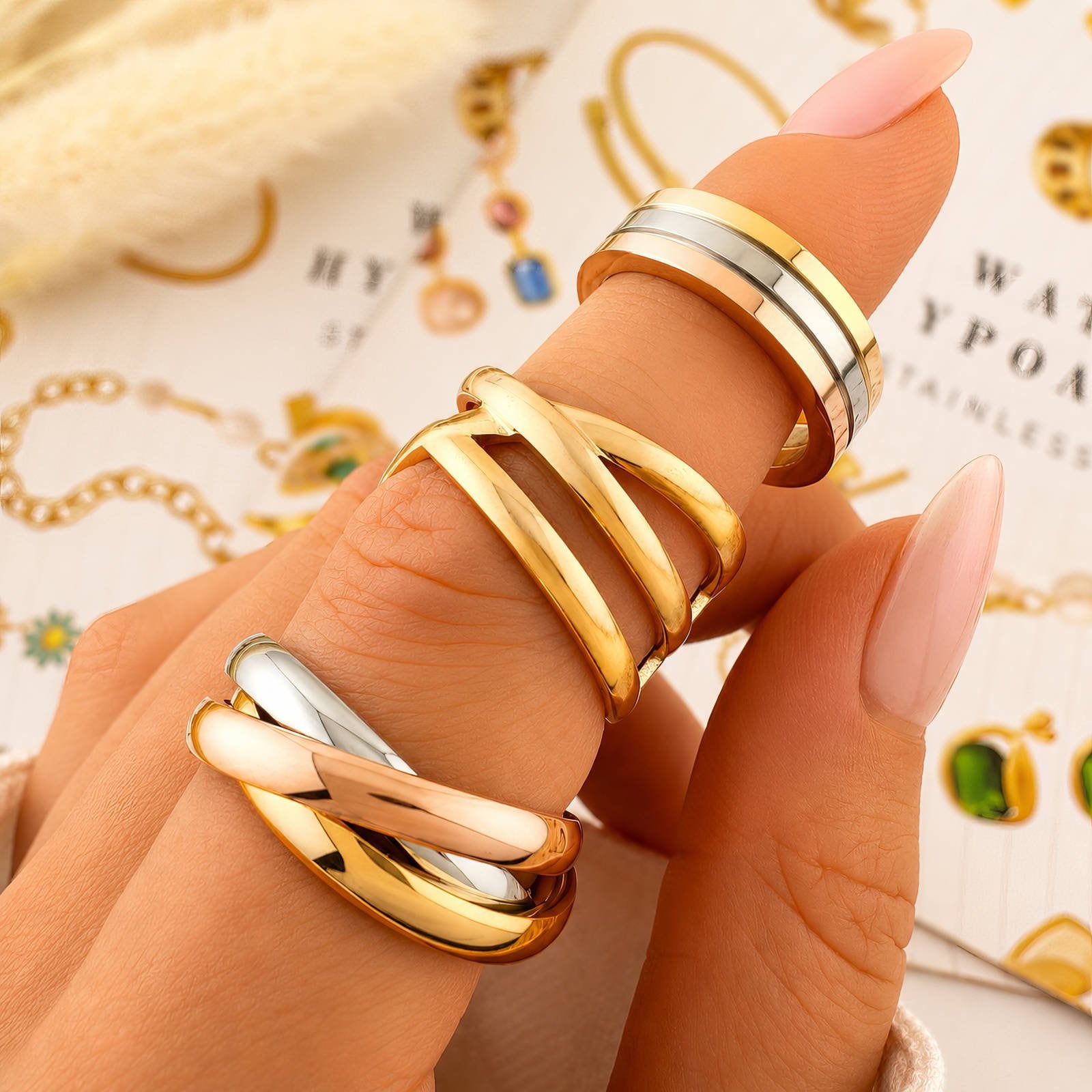 Dreiring-Set am Finger: goldene, silberne und roséfarbene Ringbänder