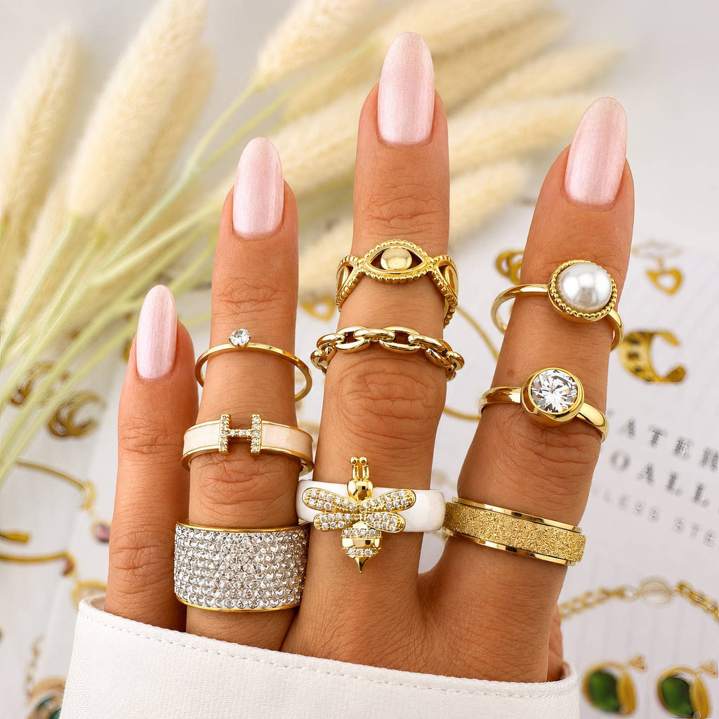 Goldfarbener Ring mit rundem Stein, im Set mit weiteren Ringen am Finger
