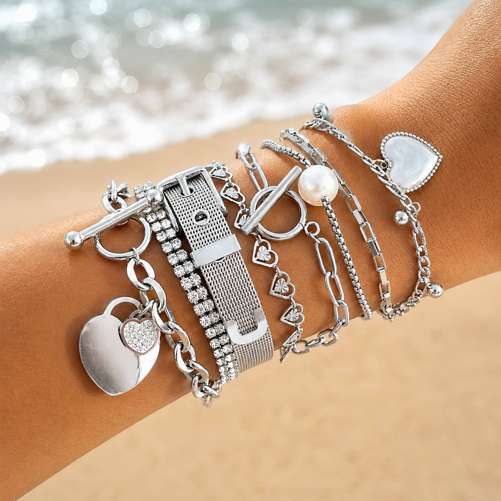 NOÉ Edelstahl-Armband mit Kettengliedern und mehreren Anhängern am Handgelenk
