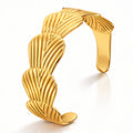 Maris Armreif aus vergoldetem Stahl mit geripptem, gebogenem Streifenmuster in Gold