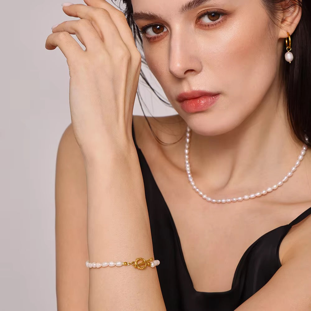 Frau trägt das CLARA Armband aus echten Süßwasserperlen am Handgelenk