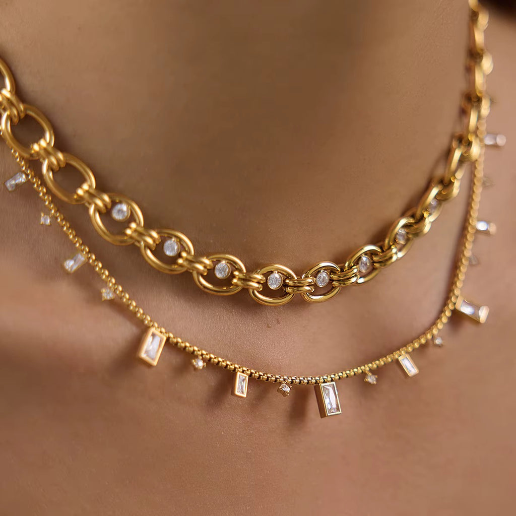Gliederkette Maille in Gold am Hals getragen, kombiniert mit einer feineren Kette