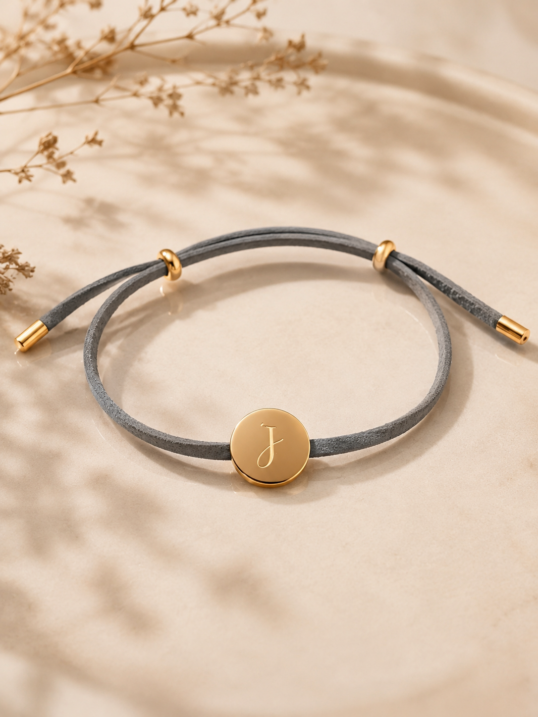 JOURÉ Signature-Armband mit grauem Textilband und runder goldfarbener Plakette